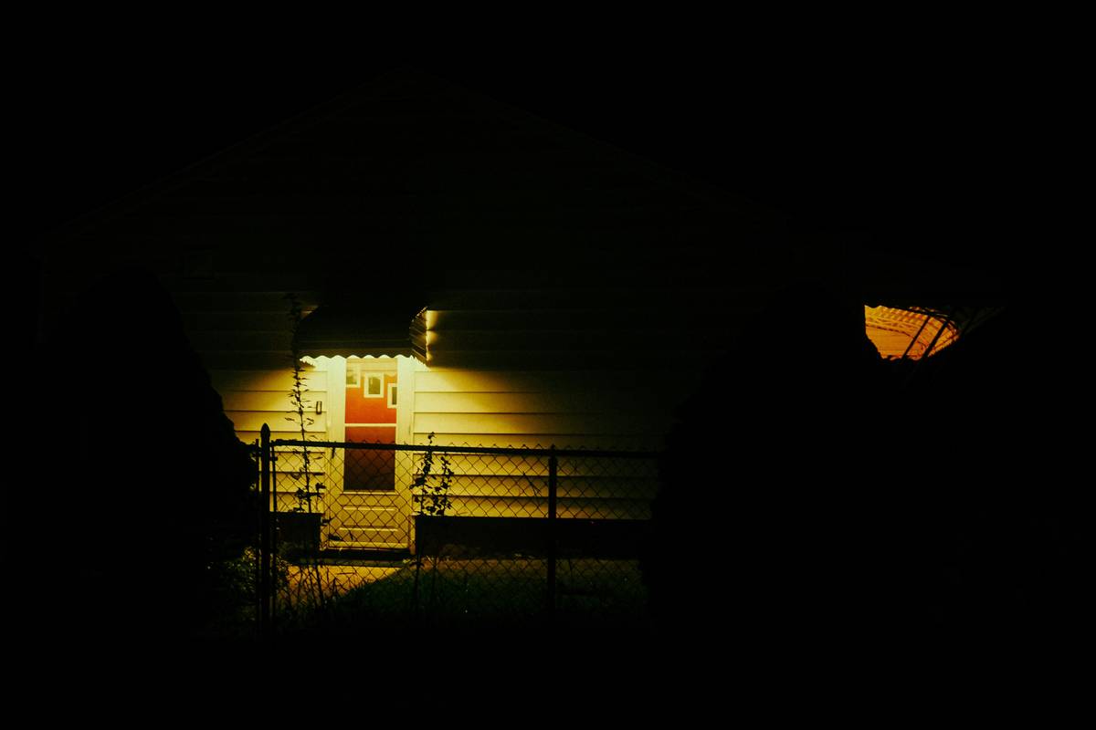 Motion-activated home outside security lights illuminating backyard entry point